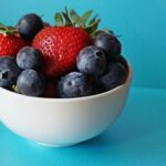 blueberries and strawberries in white ceramic bowl