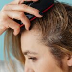 a close up shot of a woman brushing her hair