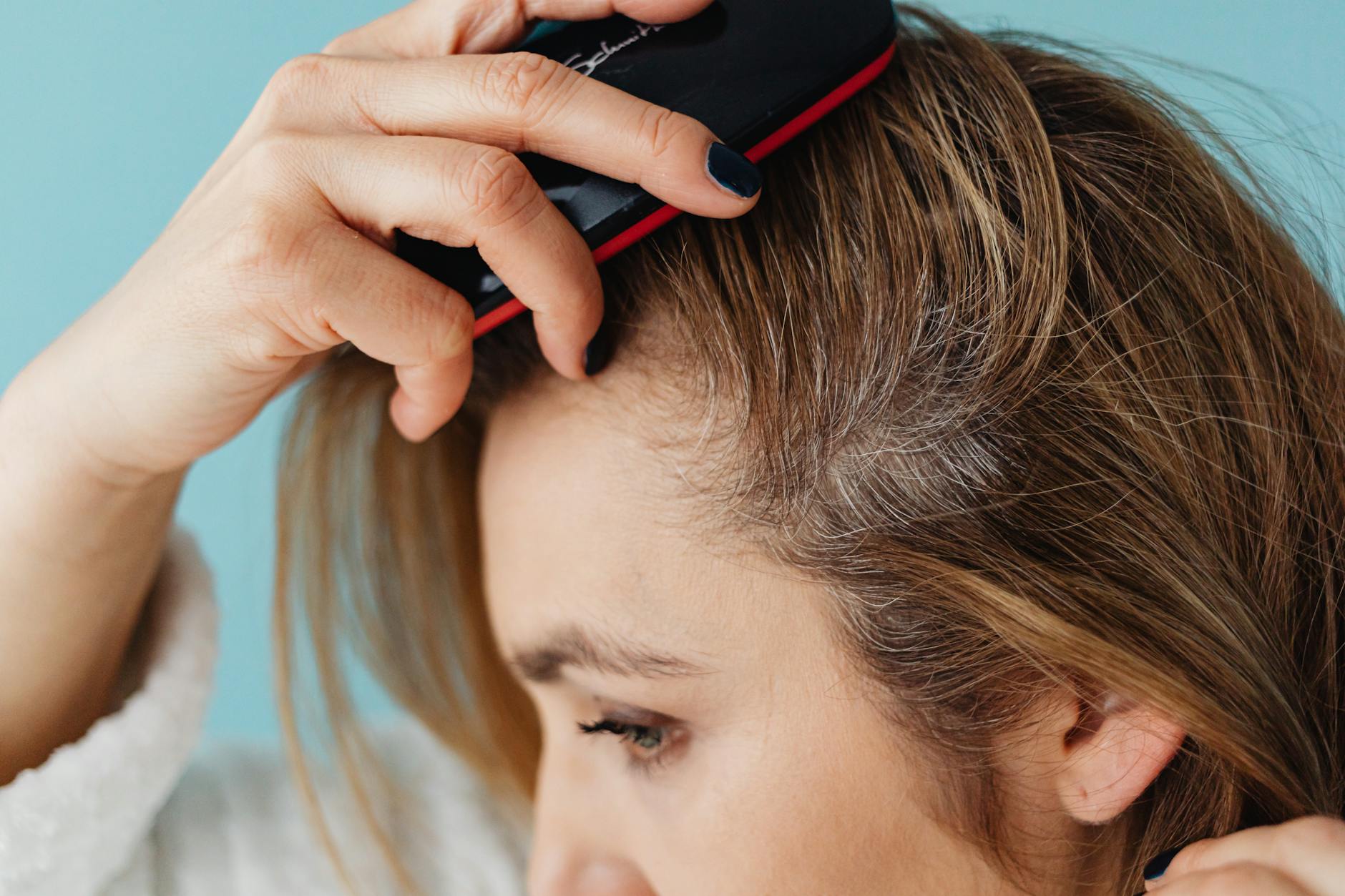 a close up shot of a woman brushing her hair