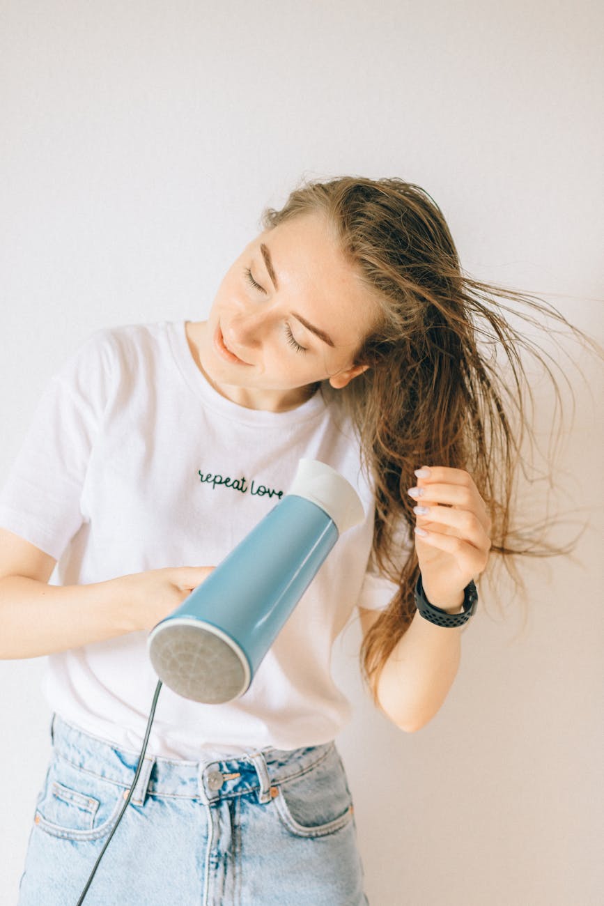 woman in white shirt drying her hair